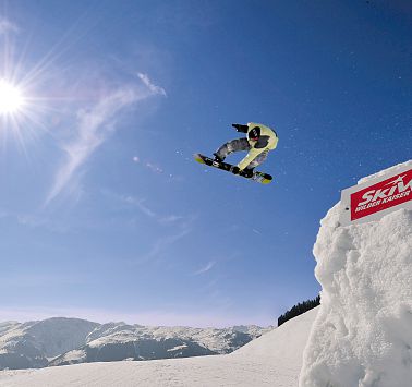 Ein Snowboardfahrer bei einem Stunt in der Luft