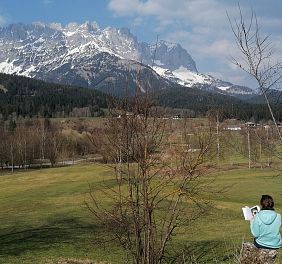 Frau mit einem Buch in der Hand mitten in der Natur