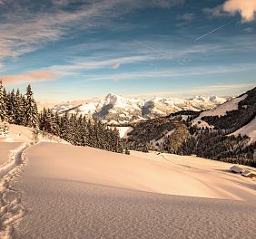 Schneebedeckte Piste mit Bergen im Hintergrund