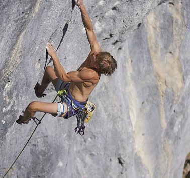 Kletterer Alex Megos gesichert am Fels
