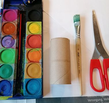Wasserfarben und Bastelmaterial auf einem Tisch