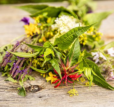 Bunter Wildblumenstrauß liegt auf Holztisch