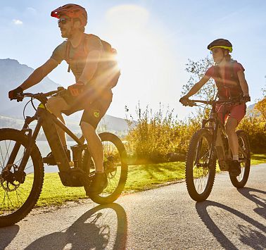 Zwei Radfahrer werden im Sonnenlicht angestrahlt