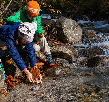 Kinder setzen Korkschiff ins Wasser