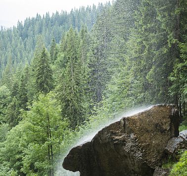 Wasser eines Wasserfalls prasselt auf einen Felsen