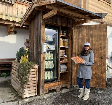 Junge Frau vor einem Schrank mit regionalen Produkten