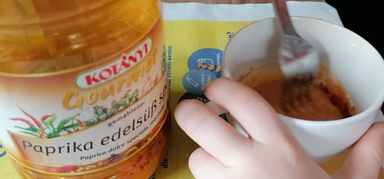 Hände rühren mit Gabel die Ostereierfabre an