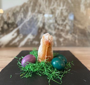 Fertiges süßes Osterlamm auf einer Steinplatte mit Ostergras