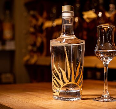 Glasflasche mit Sonne und Schnapsstamperl