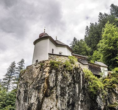 Kapelle auf einem Felsen mit düsterem Himmel