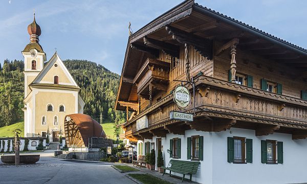 The baroque church on Goingen's village square is surrounded by the picturesque nature of the Wilder Kaiser.