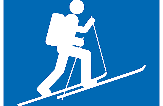 Symbol eines Skitourengehers in Weiß auf blauem Hintergrund, der mit Stöcken und Rucksack bergauf fährt.