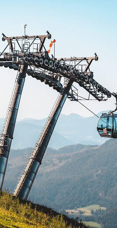 Cable car in Wilder Kaiser with stunning mountain backdrop and clear blue sky, perfect for alpine adventures.