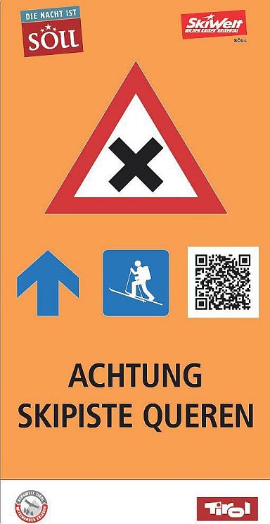 Ein Schild mit einem Schneeschuhwanderer-Symbol, einem Pfeil nach oben und einem QR-Code auf orangefarbenem Hintergrund. Ein Dreieck-Warnschild ist ebenfalls sichtbar.