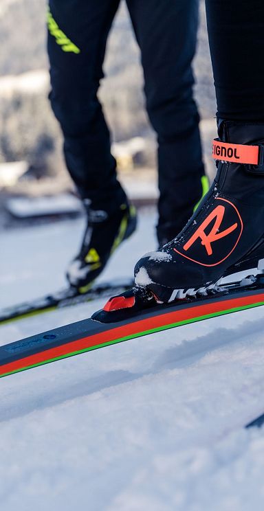Close-up of skiers' boots and skis on a snow-covered trail in the Wilder Kaiser region, illustrating the winter sports activity in this mountainous area.