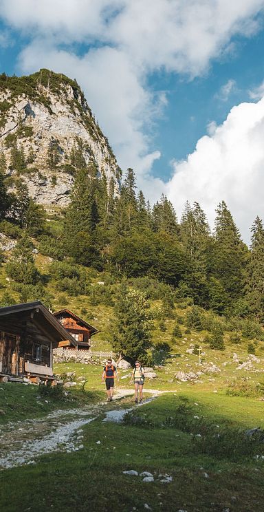 Zwei Wanderer in einem kleinen Almdorf
