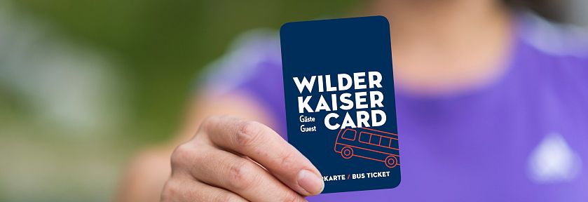 Person hält die Wilder Kaiser Card in der Hand. Die Karte bietet Vorteile in der Region Wilder Kaiser, ideal für Touristen und Naturliebhaber.