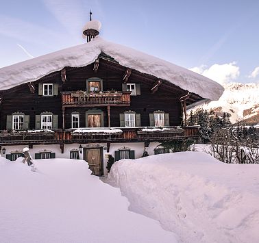 Vom Schnee befreiter Weg führt zur zugeschneiten Bergdoktorpraxis