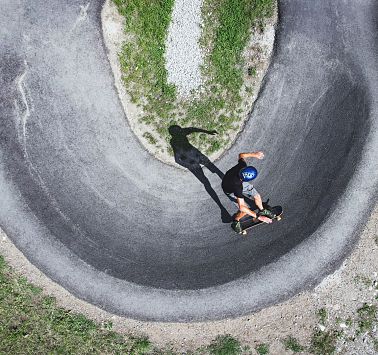 Skateboarder fährt auf asphaltiertem Pumptrack