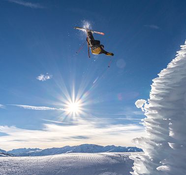 Ein Skifahrer nach dem Absprung in der Luft