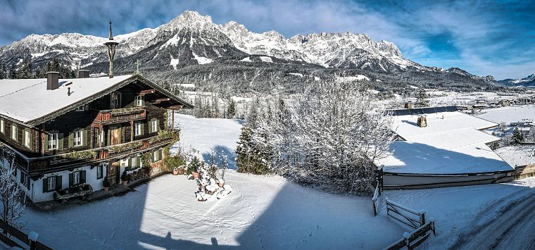 Panoramaaufnahme eines Bauernhauses in verschneiter Landschaft