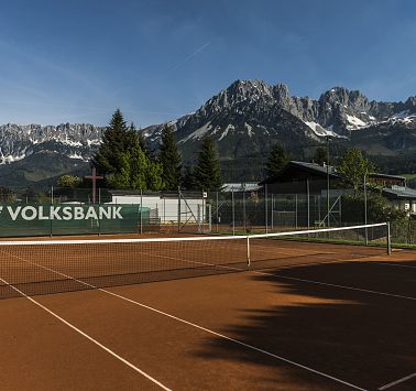 Sonniger Tennisplatz vor Gebirgszug