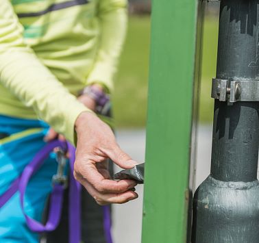 Eine Person die eine Tüte für Hundehäufchen aus einem Spender zieht